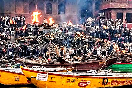 Manikarnika Ghat, le quattro del pomeriggio: le pire ardono senza sosta, ai piedi delle torri del tempio.
