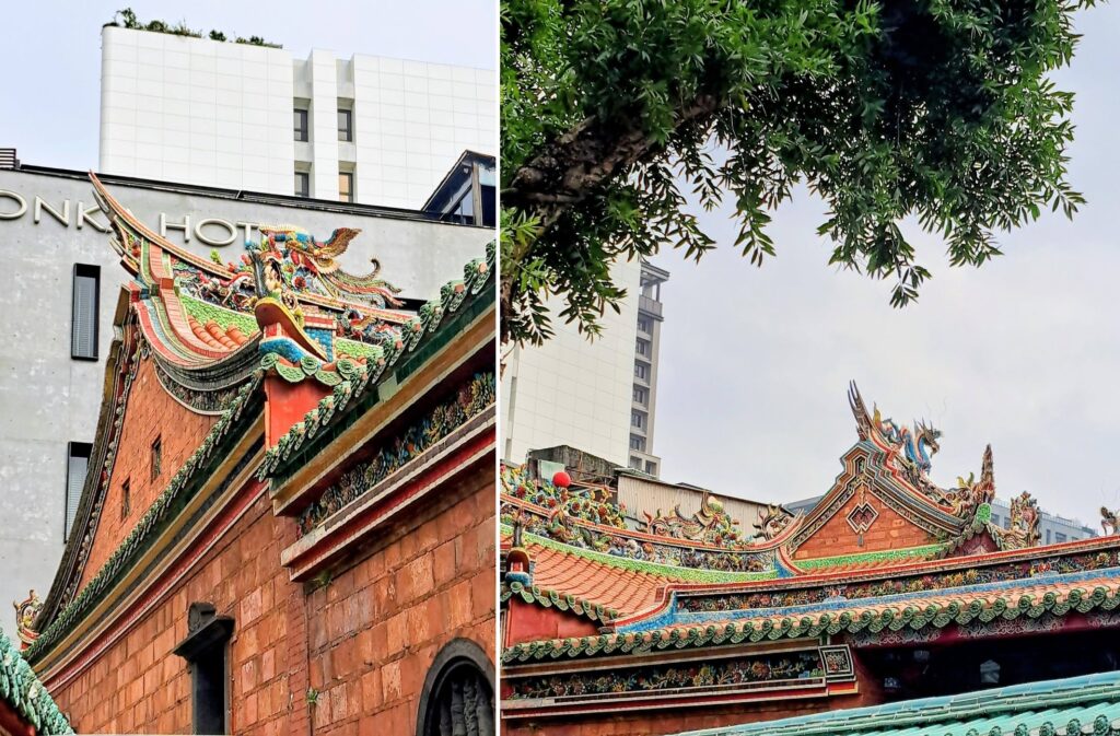 Il profilo del tetto contro l'insegna di un hotel moderno — e un ramo verde che incornicia la cresta del tetto, con un drago in ceramica policroma