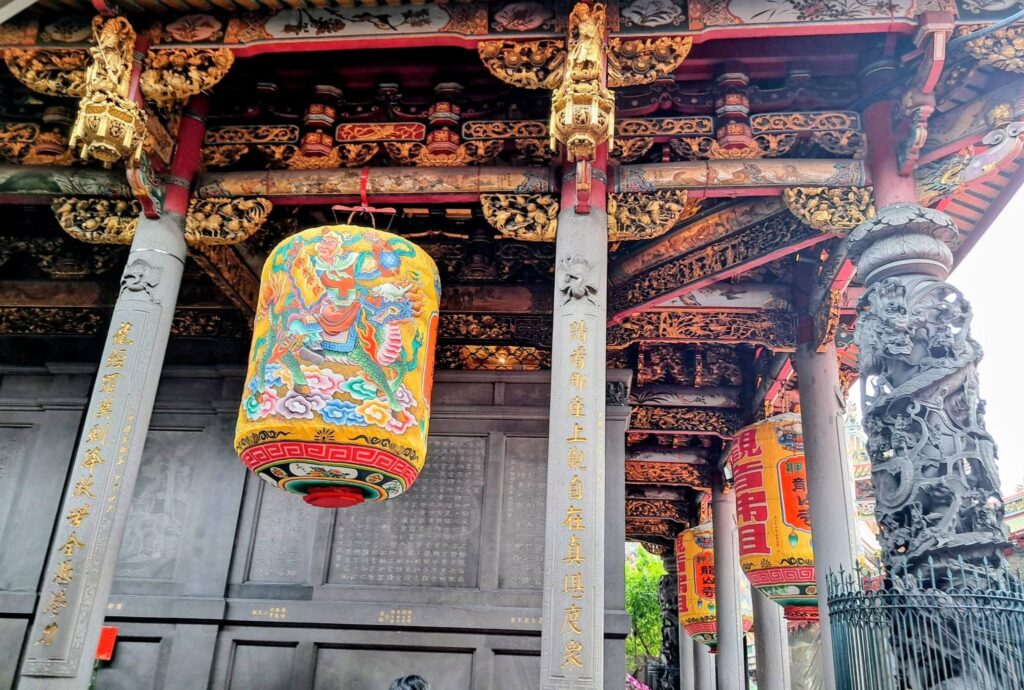 I corridoi laterali del Longshan Temple: lanterne dipinte a mano e colonne in pietra scolpita